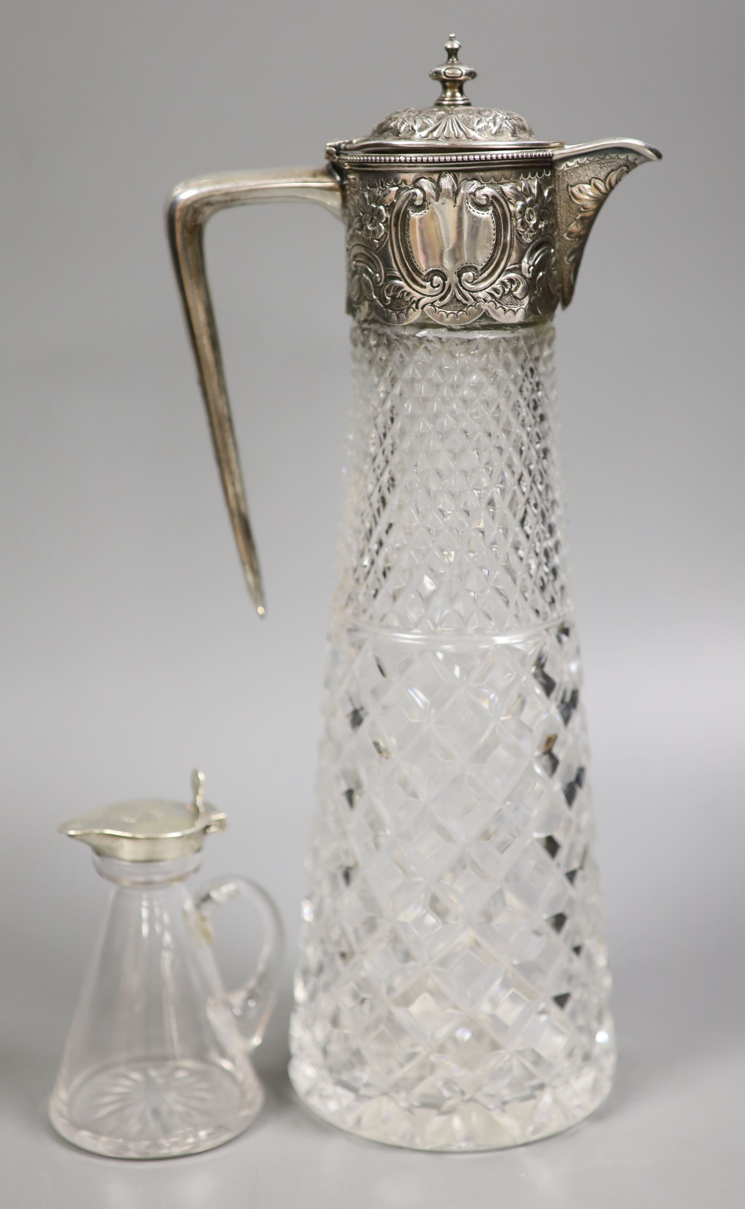 A late Victorian silver mounted cut glass claret jug, Atkin Bros. Sheffield, 1891, 29.4cm and a George V silver mounted glass whisky tot jug.